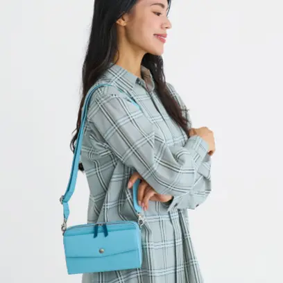 水色のショルダーバッグを掛けた女性