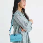 水色のショルダーバッグを掛けた女性